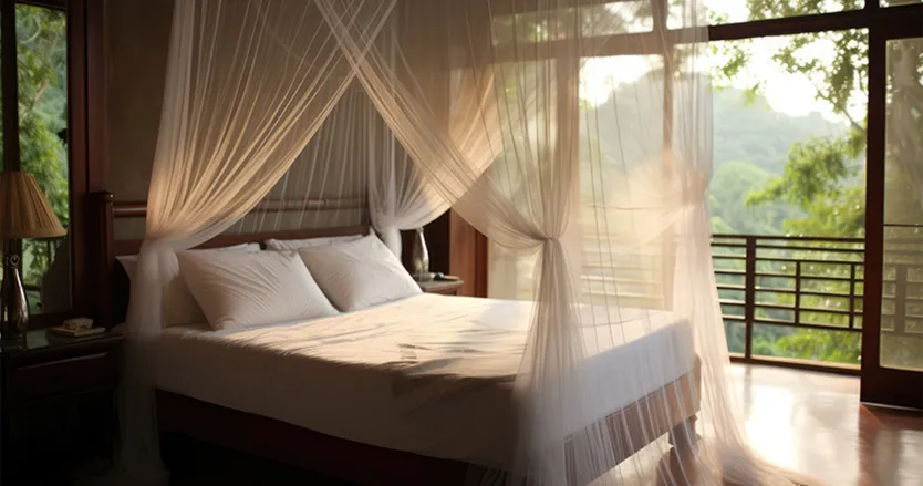 Bed in hotel room with mosquito net around it