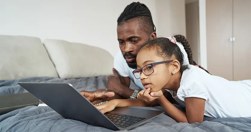 Father and daughter looking at a laptop together