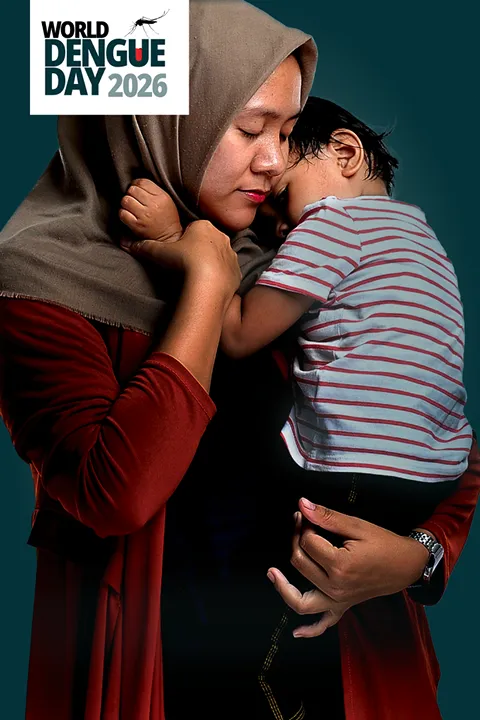Parent holding their child close against their chest, conveying the impact dengue can have on children and families