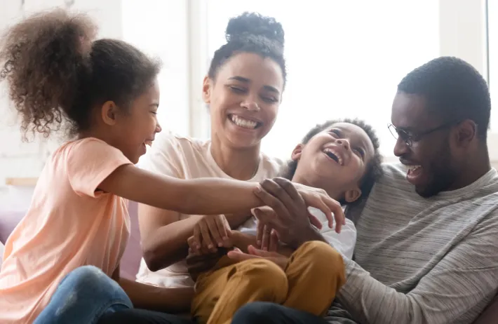 Family of four smiling and laughing together