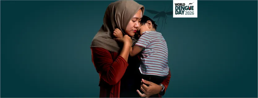 Parent holding their child close against their chest, conveying the impact dengue can have on children and families.